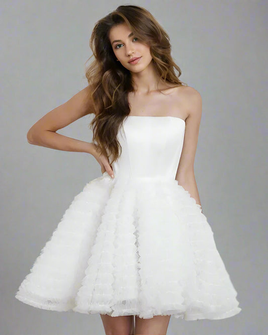 Modern woman in mini short strapless wedding dress with sweetheart cut neckline and fitted bodice.