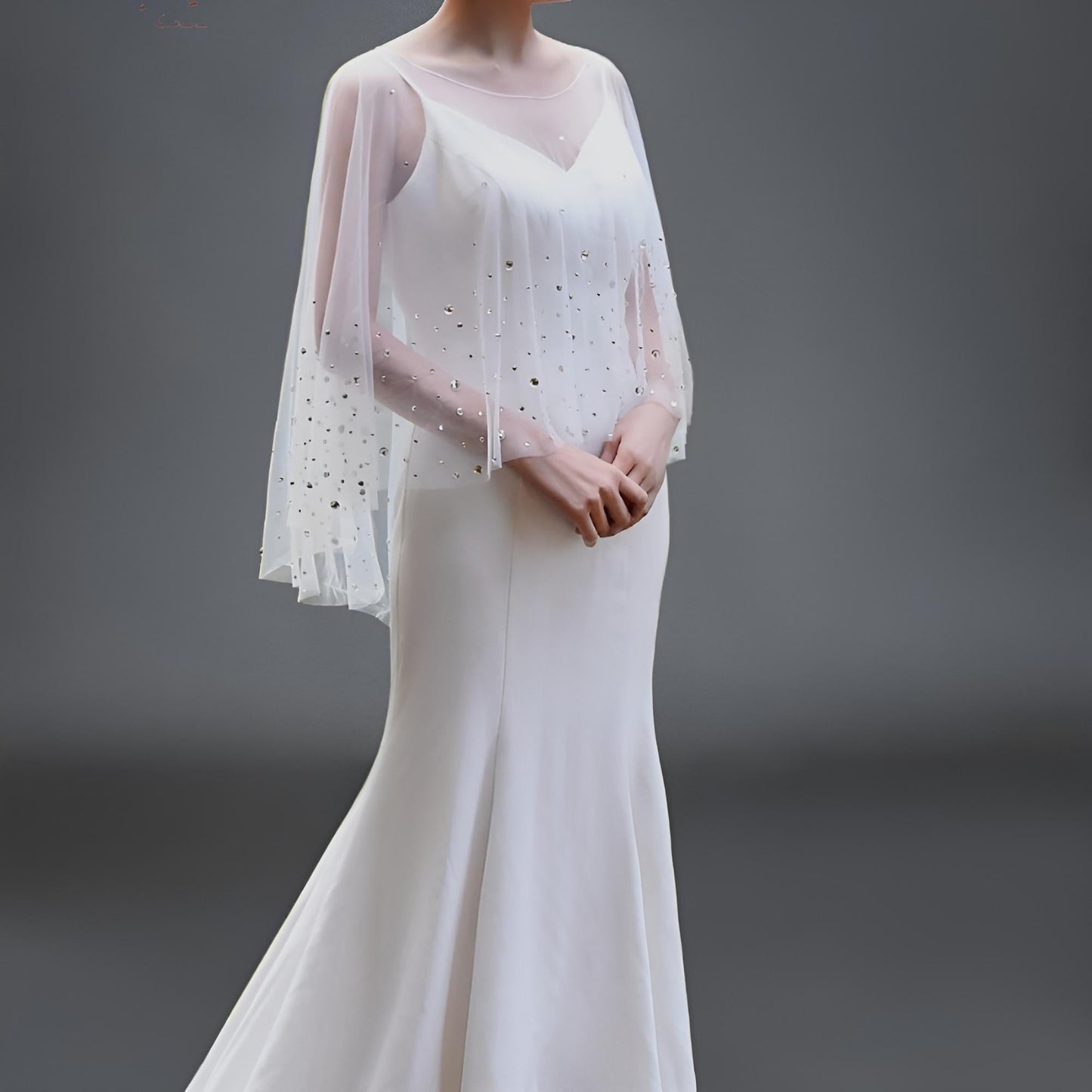 Transparent bridal cape draped over an elegant gown
