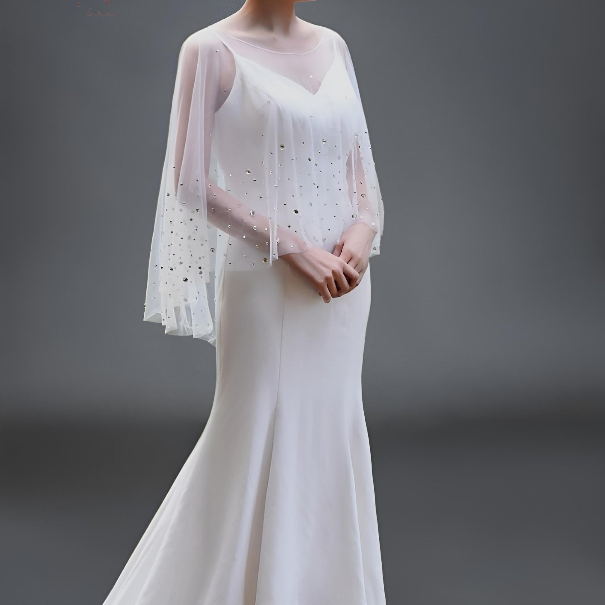 Transparent bridal cape draped over an elegant gown