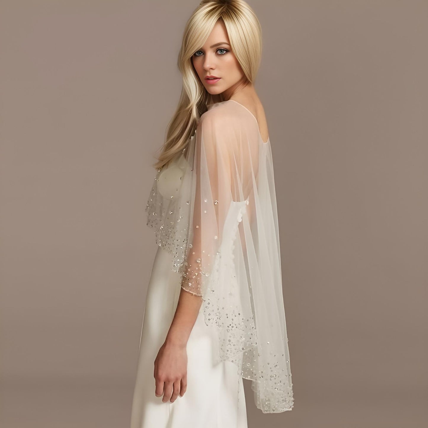Elegant bride in a rhinestone-adorned sheer cape.