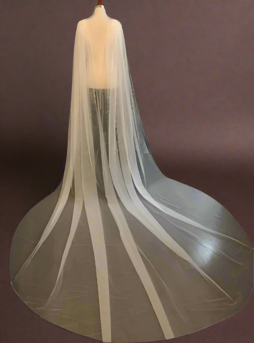 Figurine showing wearing rhinestone appliqué shoulder cape veil with V-shape back cut.