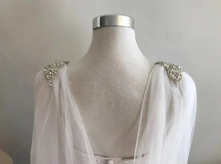 Elegant bridal rhinestone appliqué cape veil from back with raw cut edge.