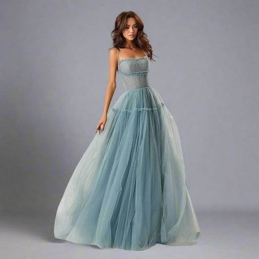Woman wearing  light blue colored the SARKA Formal Couture Dress with pleated bodice and flowing tulle skirt.