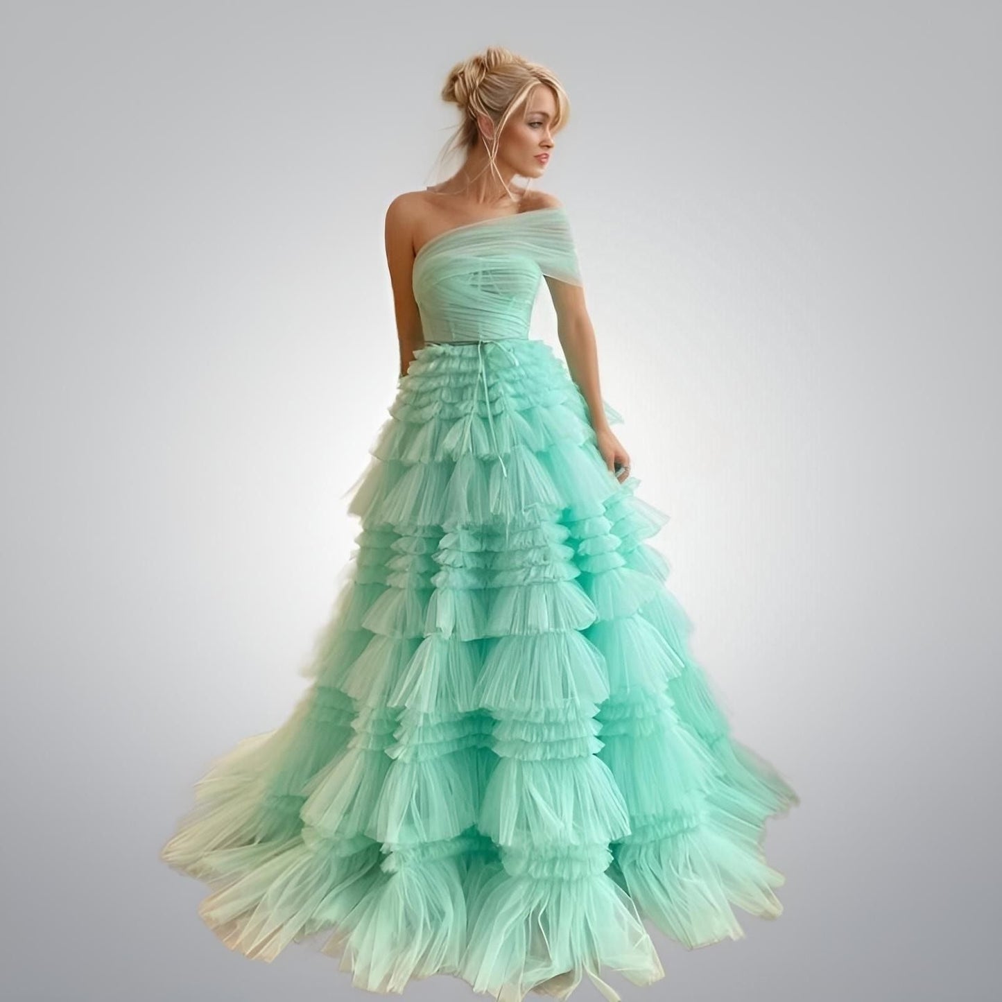 Model wearing the Scarlett Dress in Mint Green, showcasing its elegant tiered silhouette.