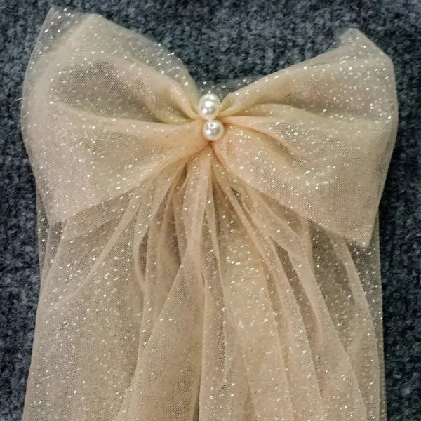 Flat lay of the Glitter Sparkling Bridal Wings Veil with pearls and luxurious bows.