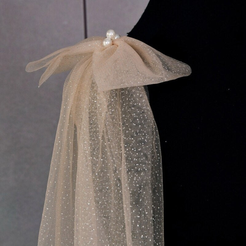 Detail of the luxurious bows on the Glitter Sparkling Bridal Wings Veil. - Champagne