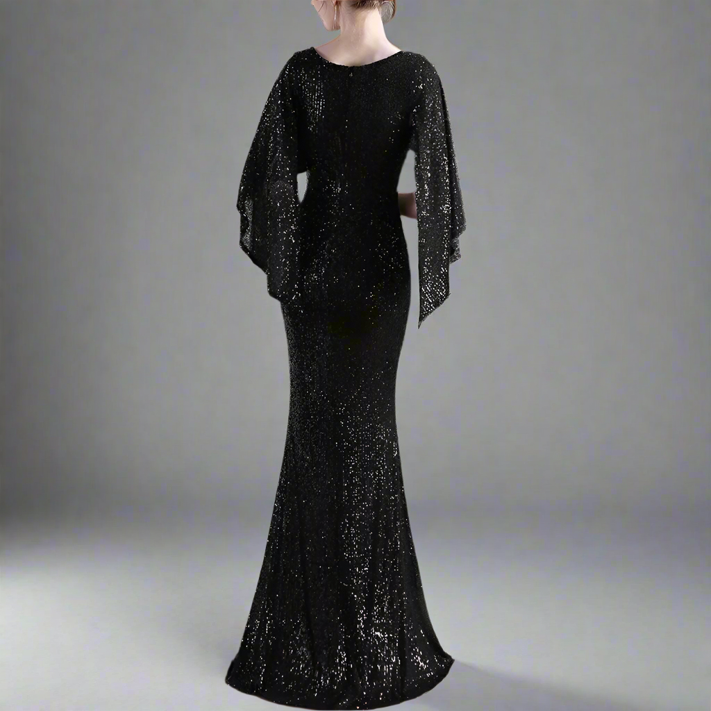 Black sequin dress with cape worn by a model in a studio from back