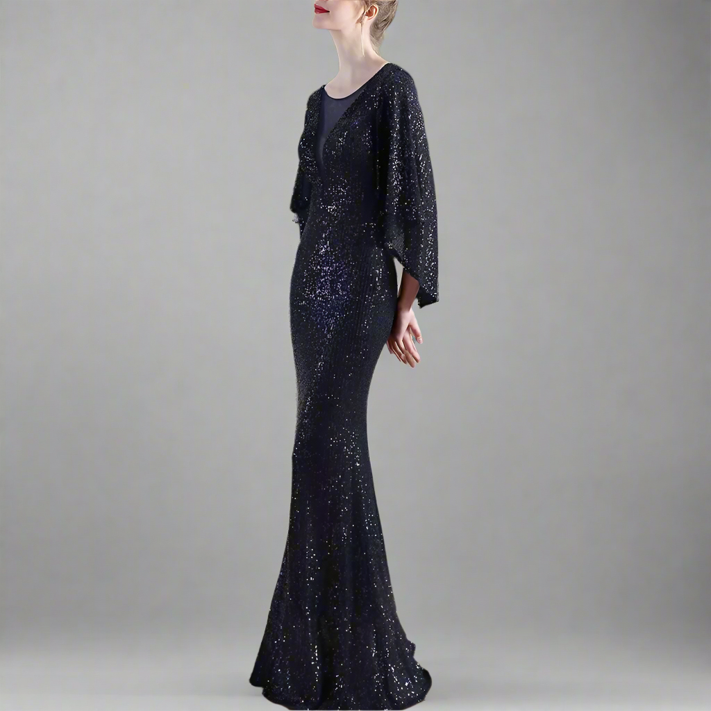Woman in a sparkly navy evening gown posing in studio.
