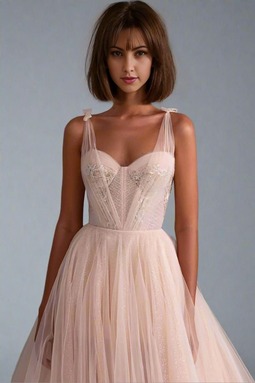 Brunette in elegantly embroidered A-line prom gown with lace and tulle skirt.