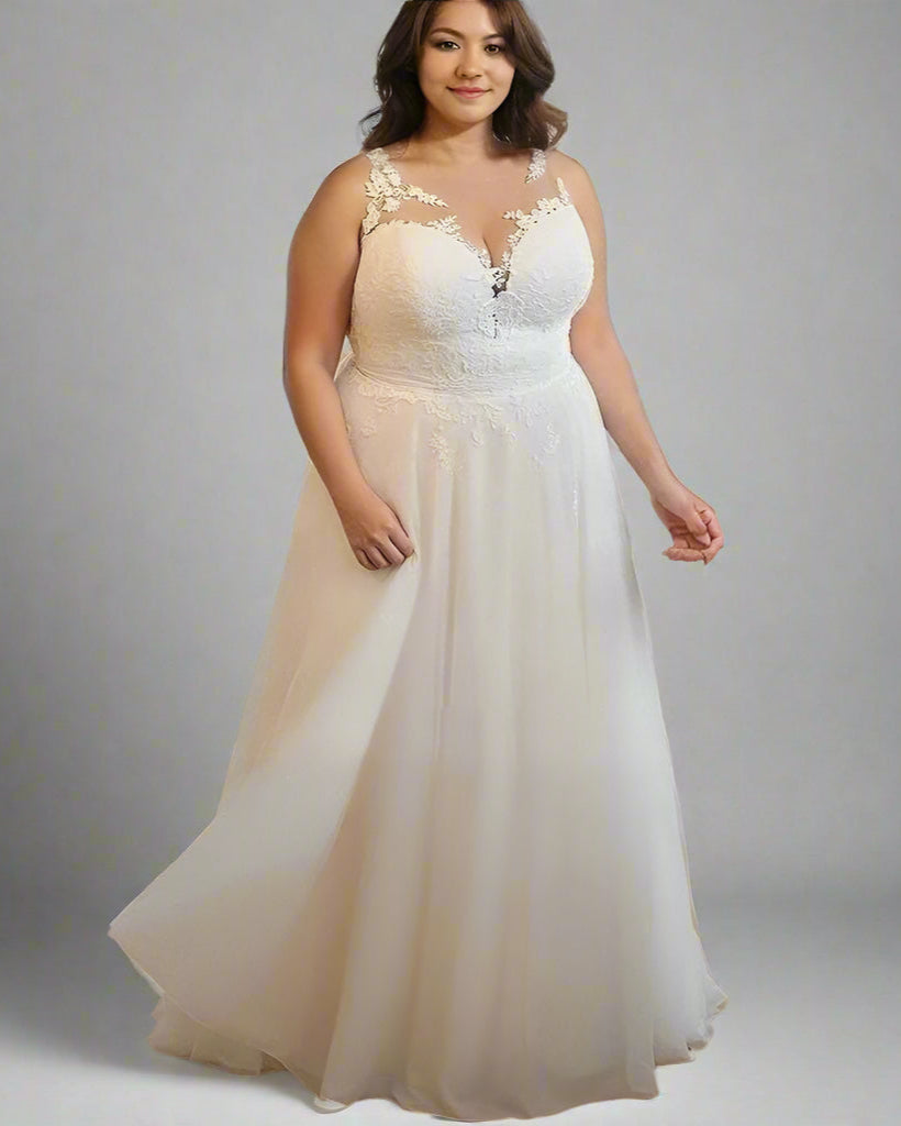 Flowing soft tulle layers on a romantic plus size bridal gown with lace V-neck and flattering A-line silhouette.