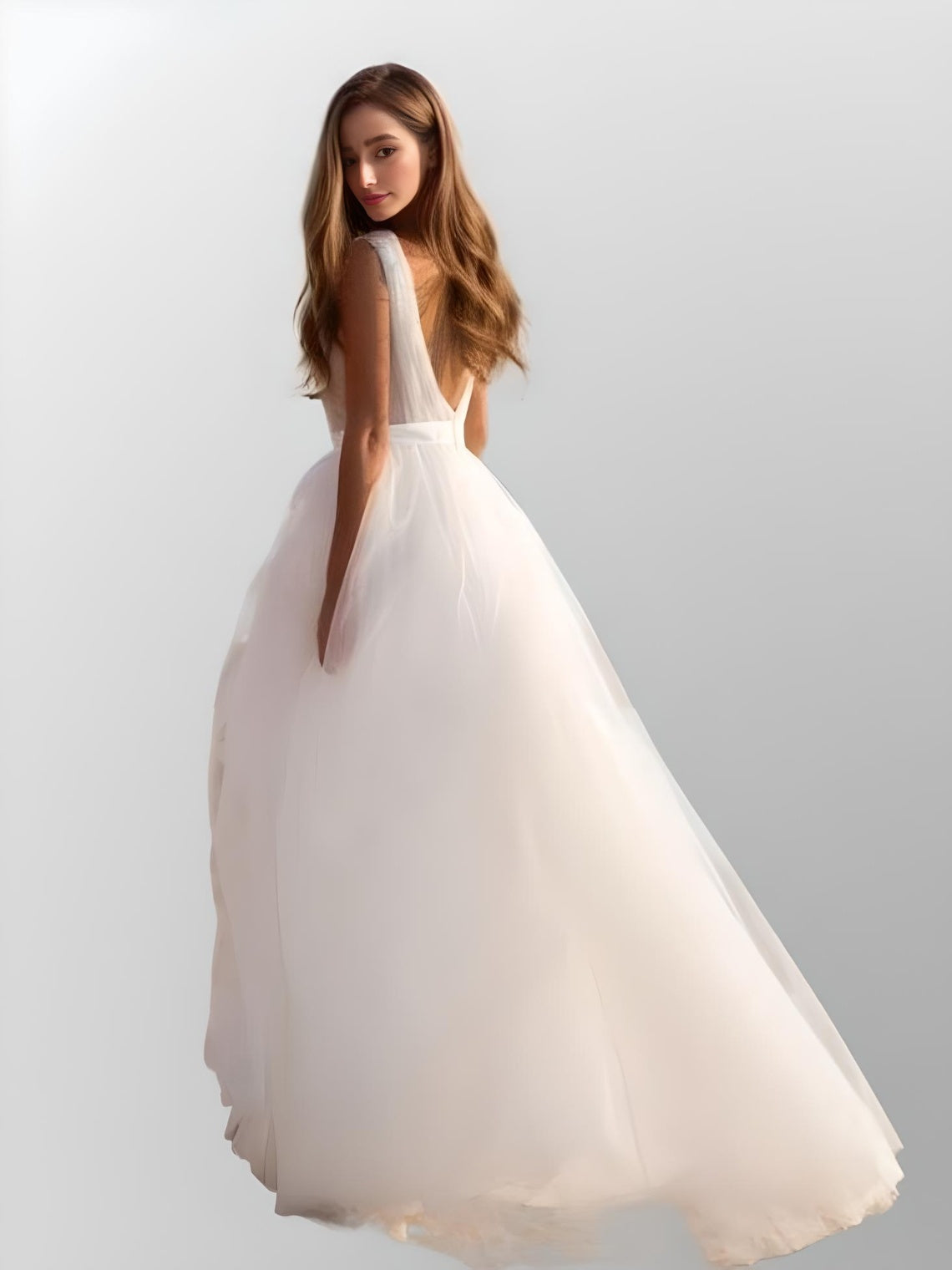Bride with long brown wavy hair wearing the Lynley Wedding Dress showcasing its backless design.