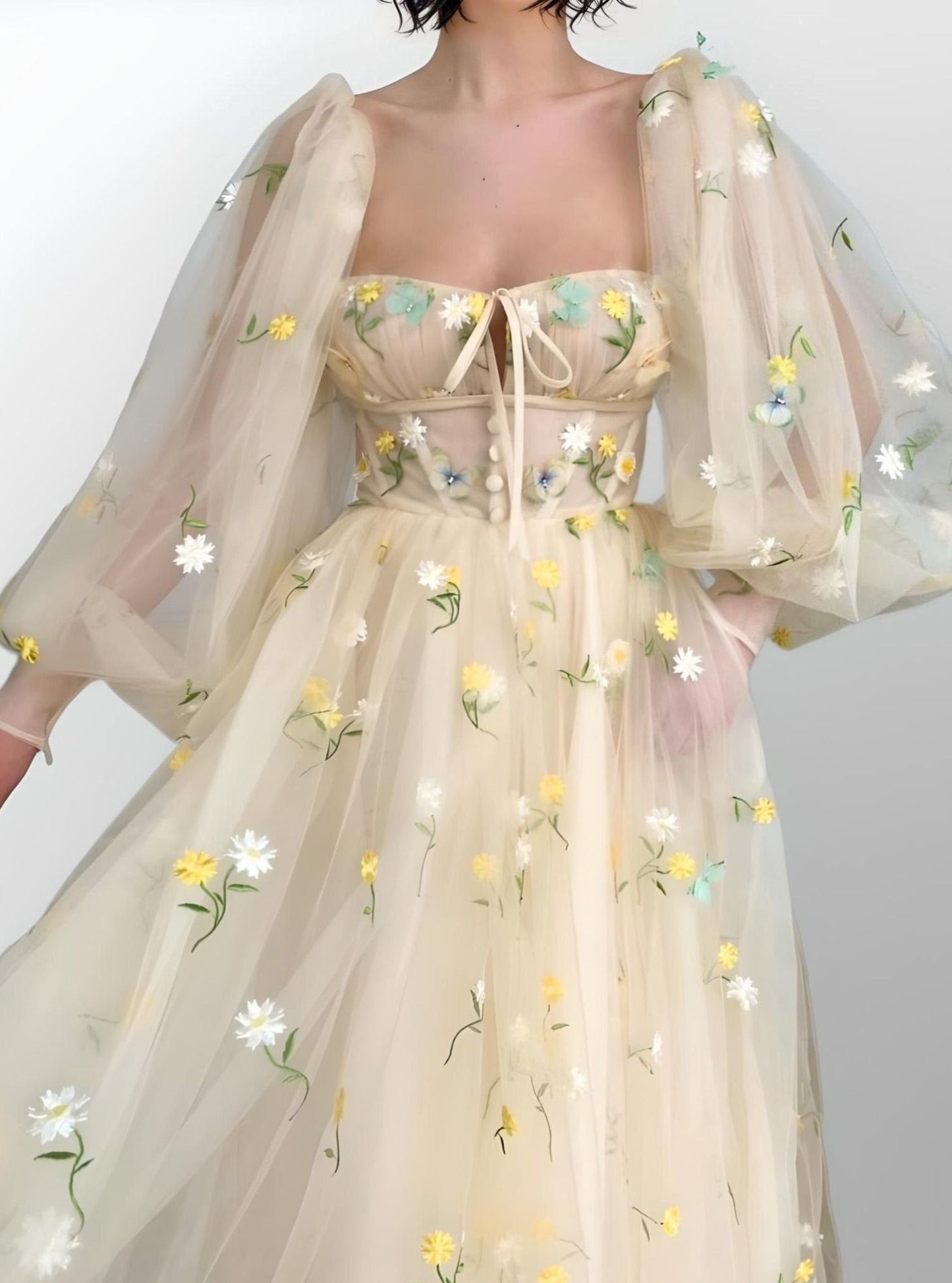 Woman showcasing beige A-line prom dress with puff sleeves