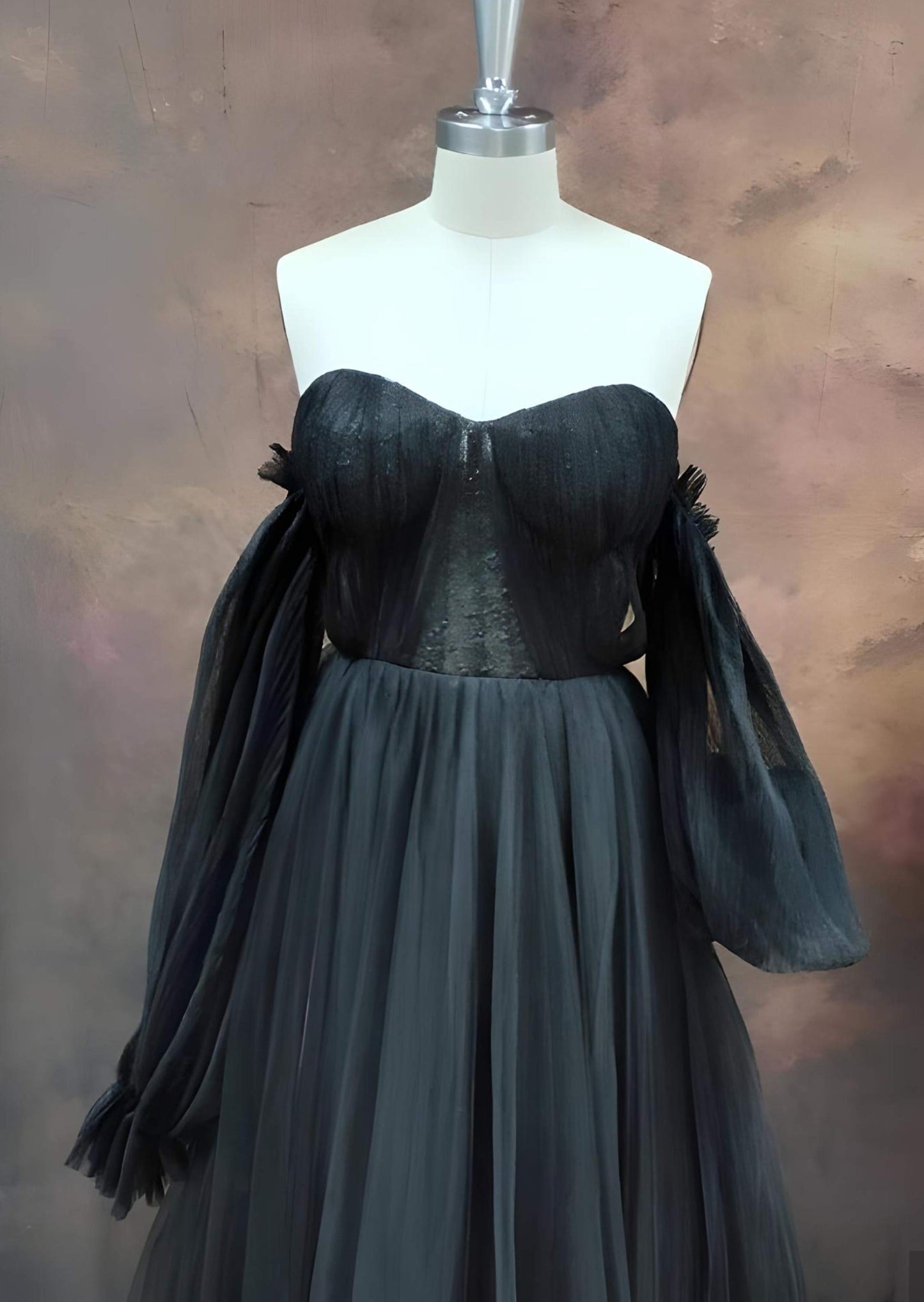 Black OLIVIA dress displayed on mannequin, showcasing dress design and puff sleeves