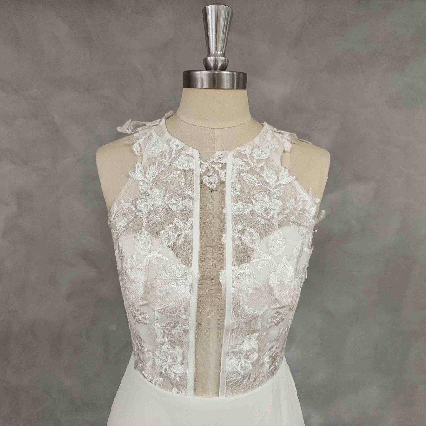 Close-up of lace details on PEYTON short wedding dress showing off neckline deep design.