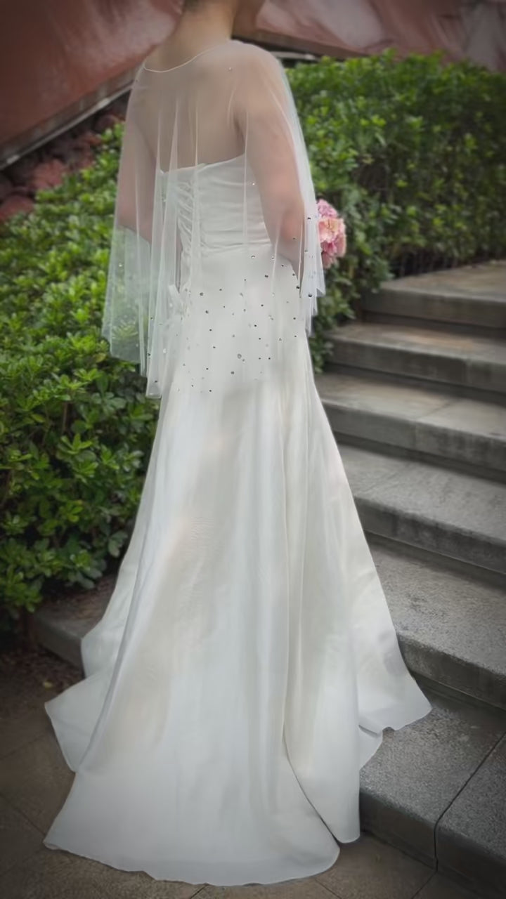 Model showcasing a wedding cape with shimmering embellishments