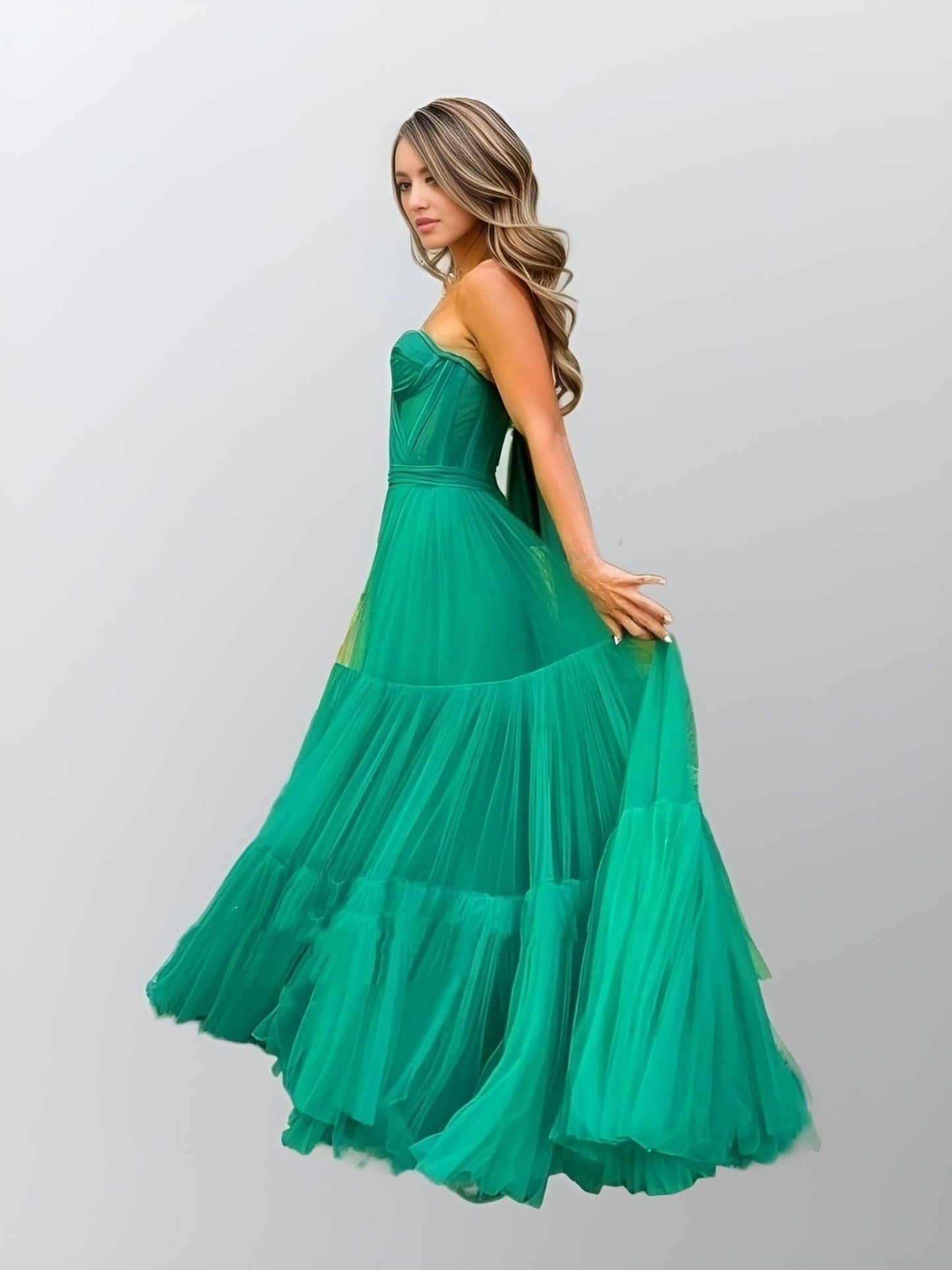 Side close-up of the tiered green tulle detail on the Raegan evening gown.