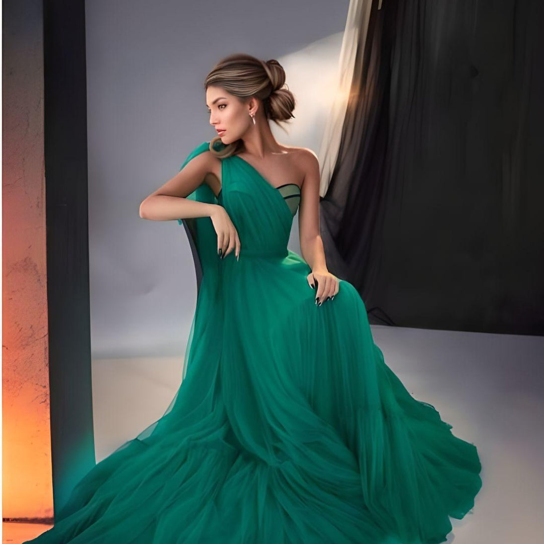 Model posing on a chair in the Raegan dress in green tulle with one shoulder strap veil/train.