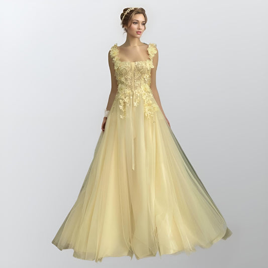 Model wearing RAYA light yellow tulle formal dress with spaghetti straps and floral appliques.