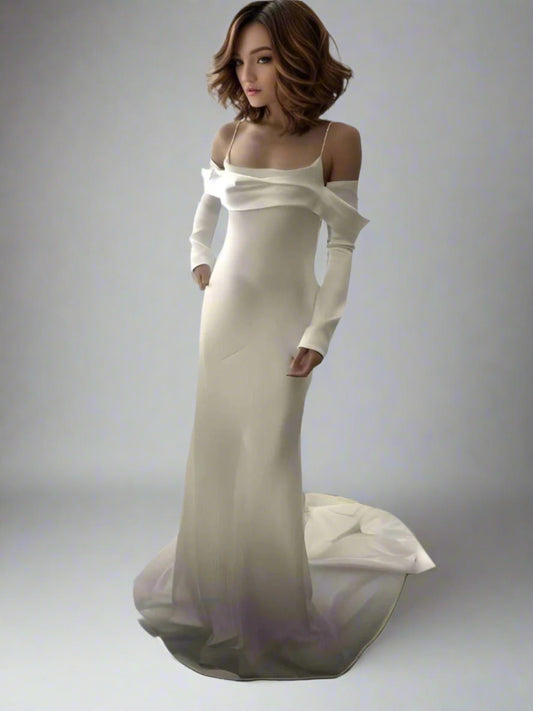 Bride posing in Reese satin wedding dress with mermaid silhouette, long sleeves and spahgetti straps.