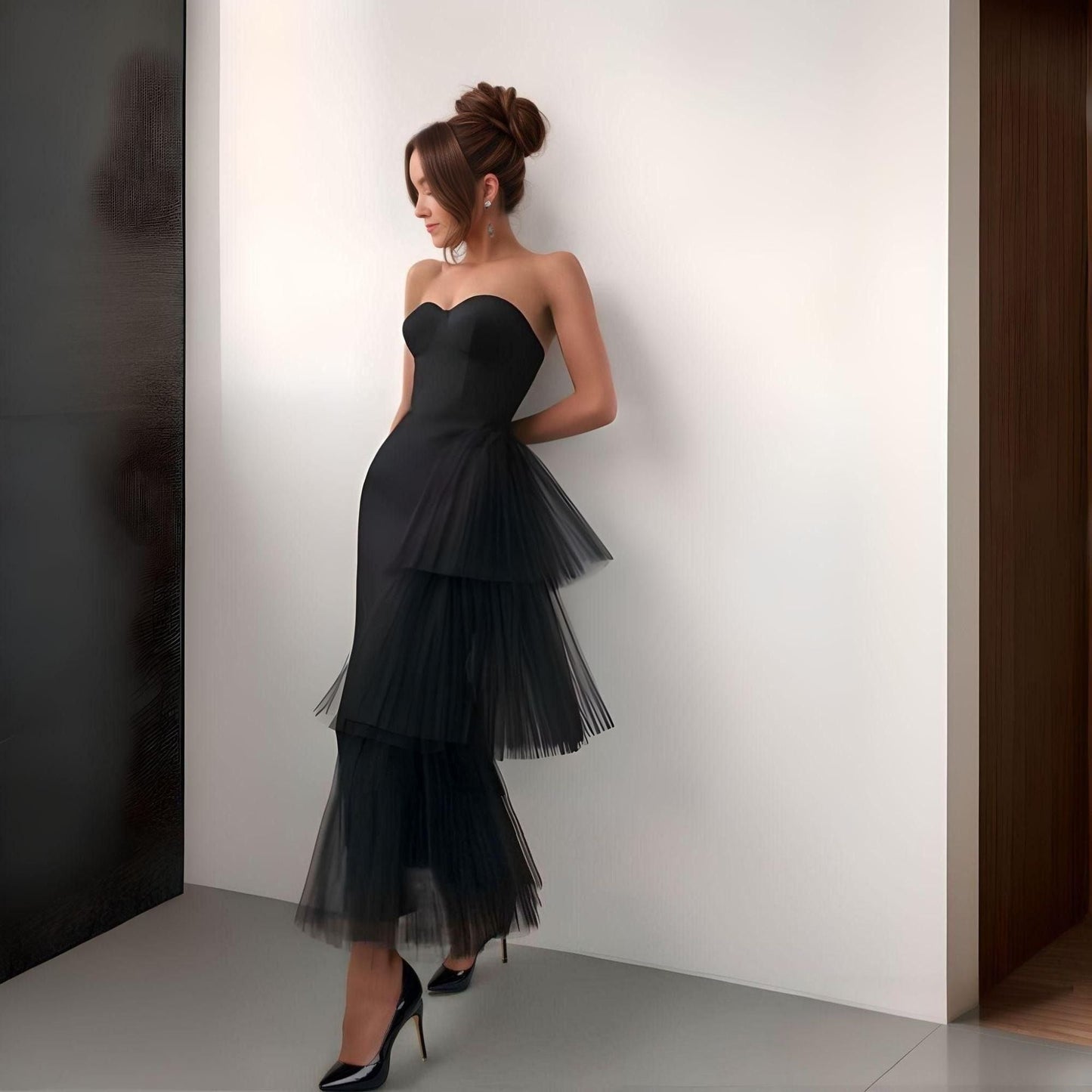 Woman wearing elegant black crepe formal dress with asymmetrical side tulle layers
