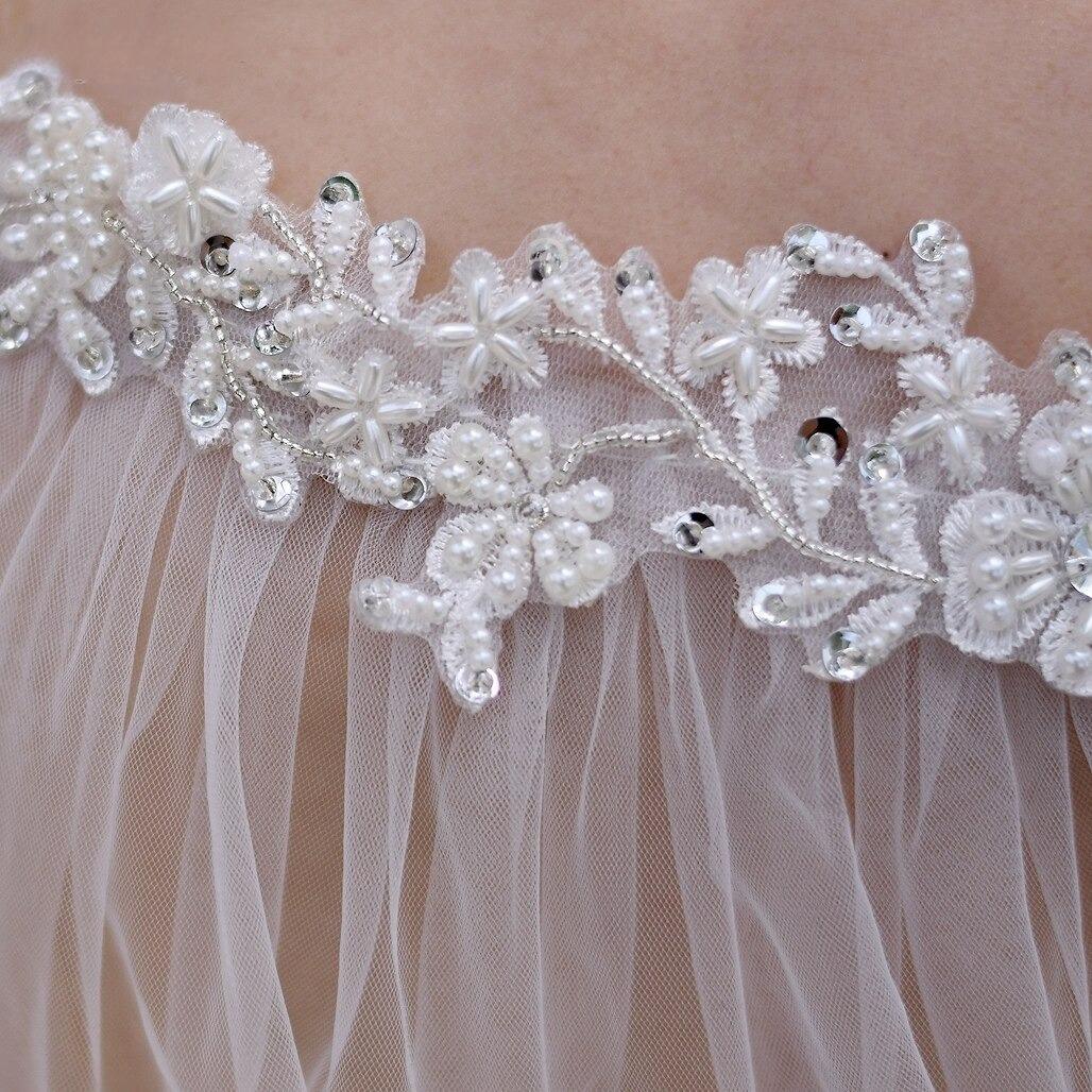 Close-up of beaded rhinestone lace details on bridal wedding cloak.