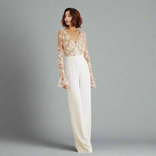 Bride wearing RYAN wedding jumpsuit with lace illusion back and long sleeves.