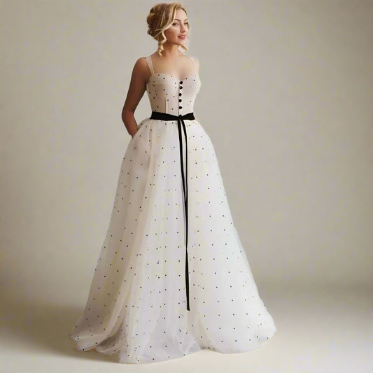Woman wearing Sanai polka dot formal dress with velvet belt and sweetheart neckline.
