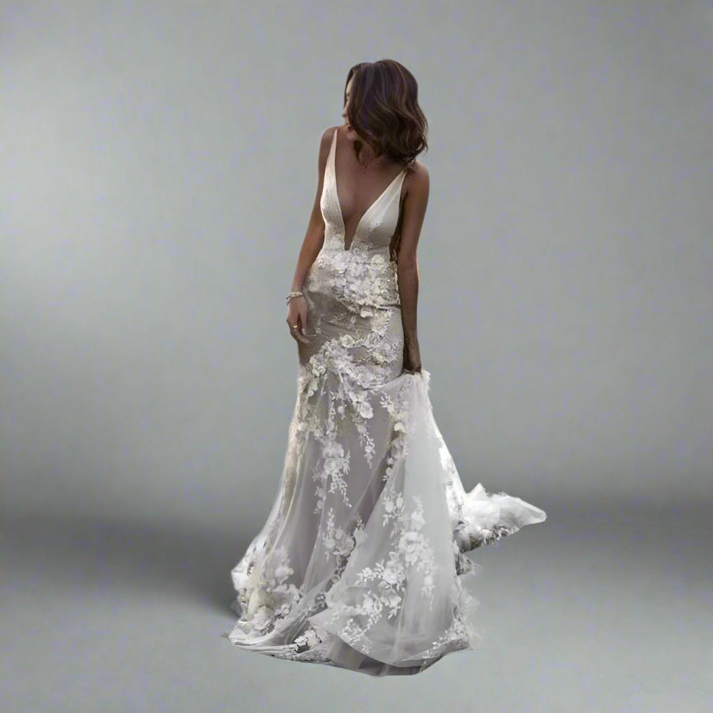 Bride wearing SANDRA wedding dress with 3D lace appliques and plunging V-neck.