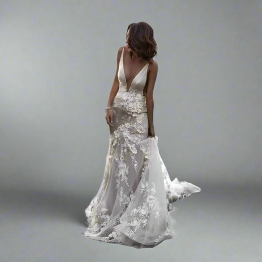 Bride wearing SANDRA wedding dress with 3D lace appliques and plunging V-neck.