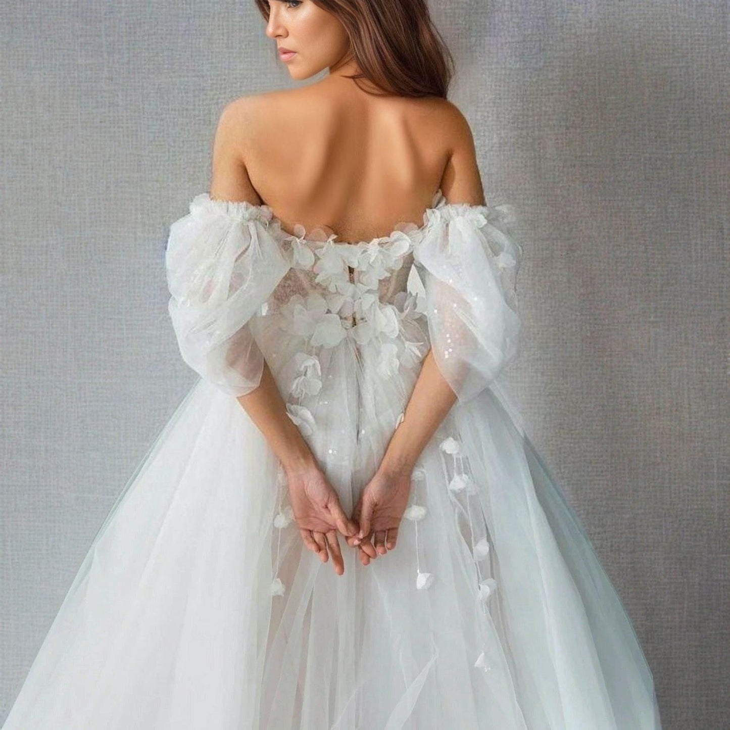 Back view of the SHERYL wedding dress showcasing its off-the-shoulder sleeves. and 3D flowers.