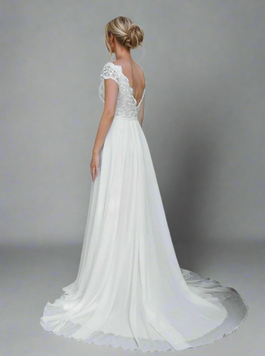 Backless view of the SKYE Wedding Dress, worn by blond bride, highlighting the deep V-neck back.