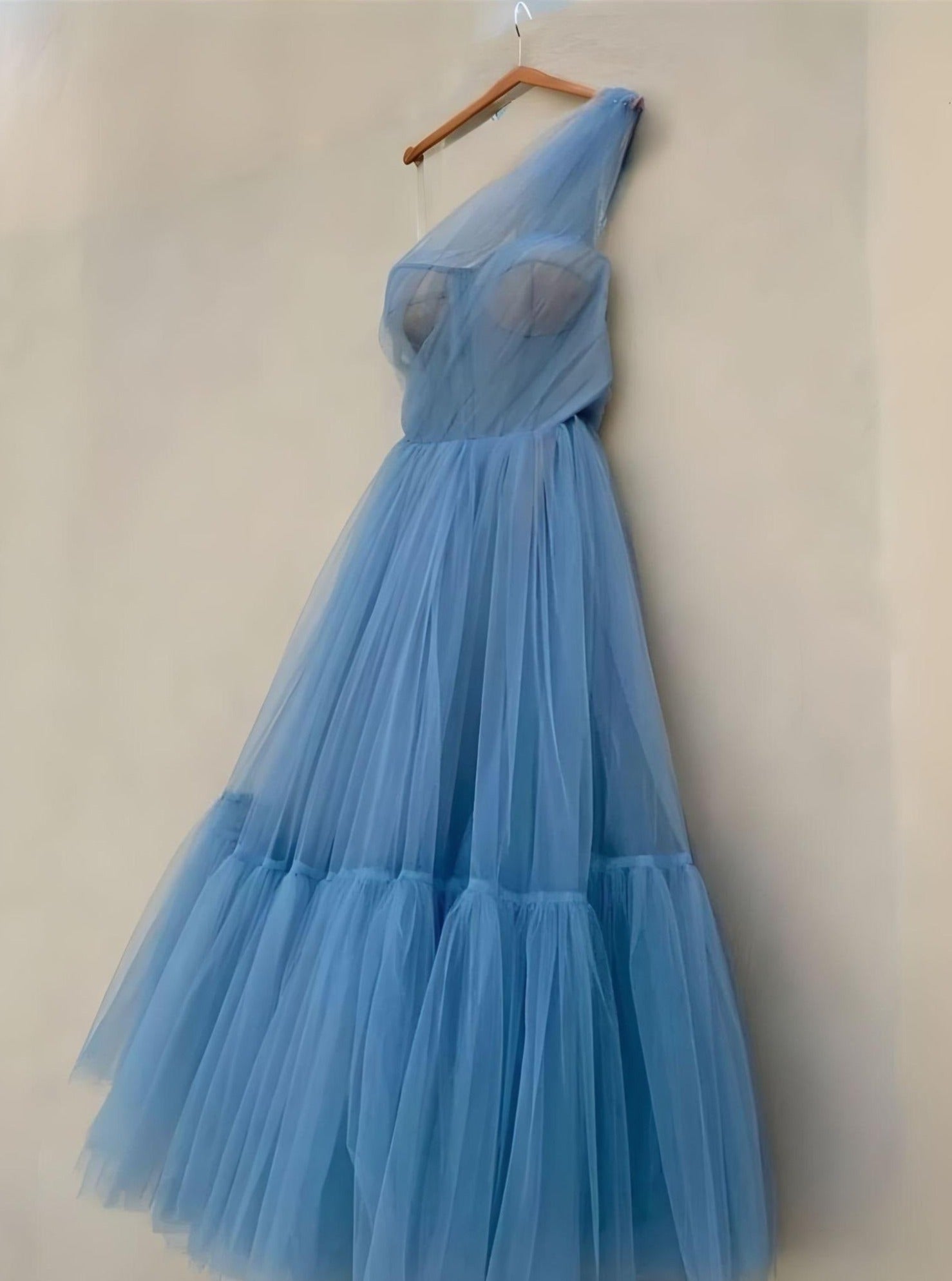 Side profile of the blue Skyler Formal Dress on hanger, emphasizing the A-line silhouette and tea-length skirt.