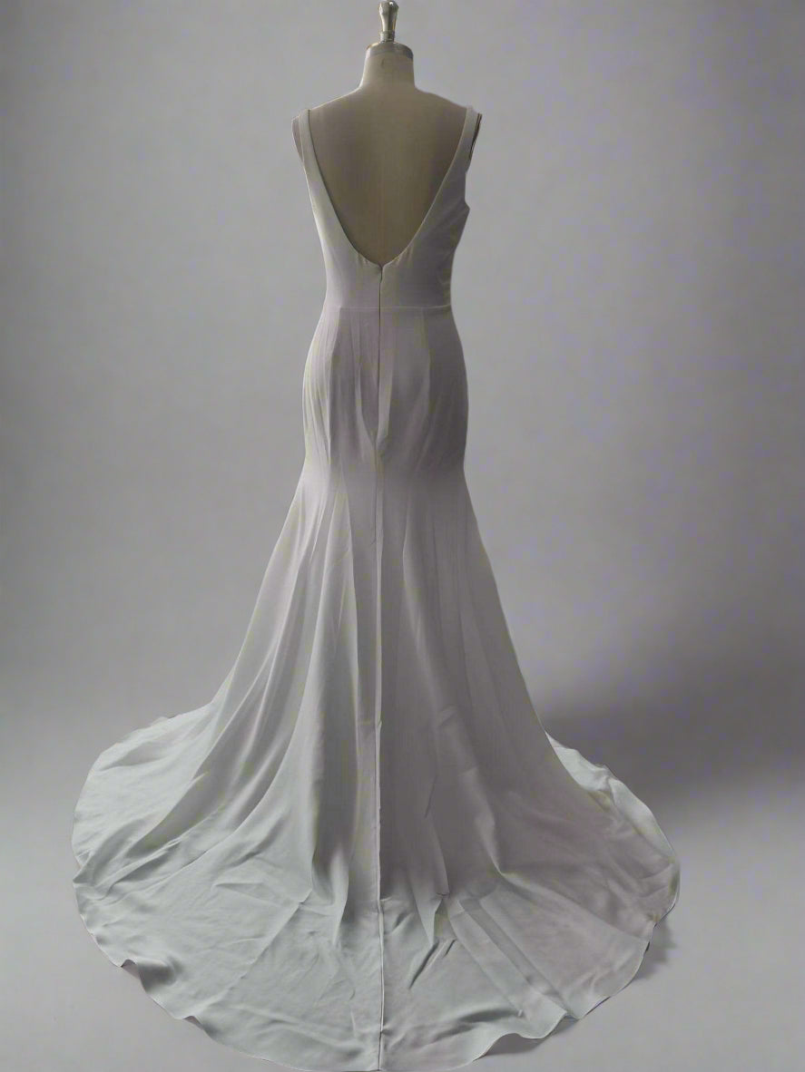 Showcase of bridal dress featuring a backless design with sweep train