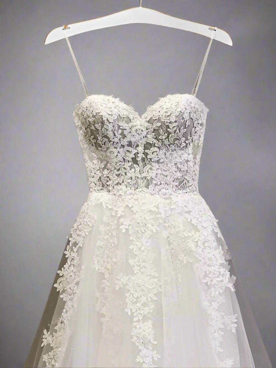 Close-up of the intricate lace details flowing from the bodice to the skirt.