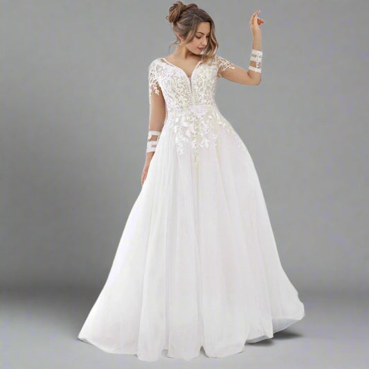 Curvy bride wearing the Tania Plus Size Wedding Dress, showcasing the lace bodice and flowing tulle skirt.