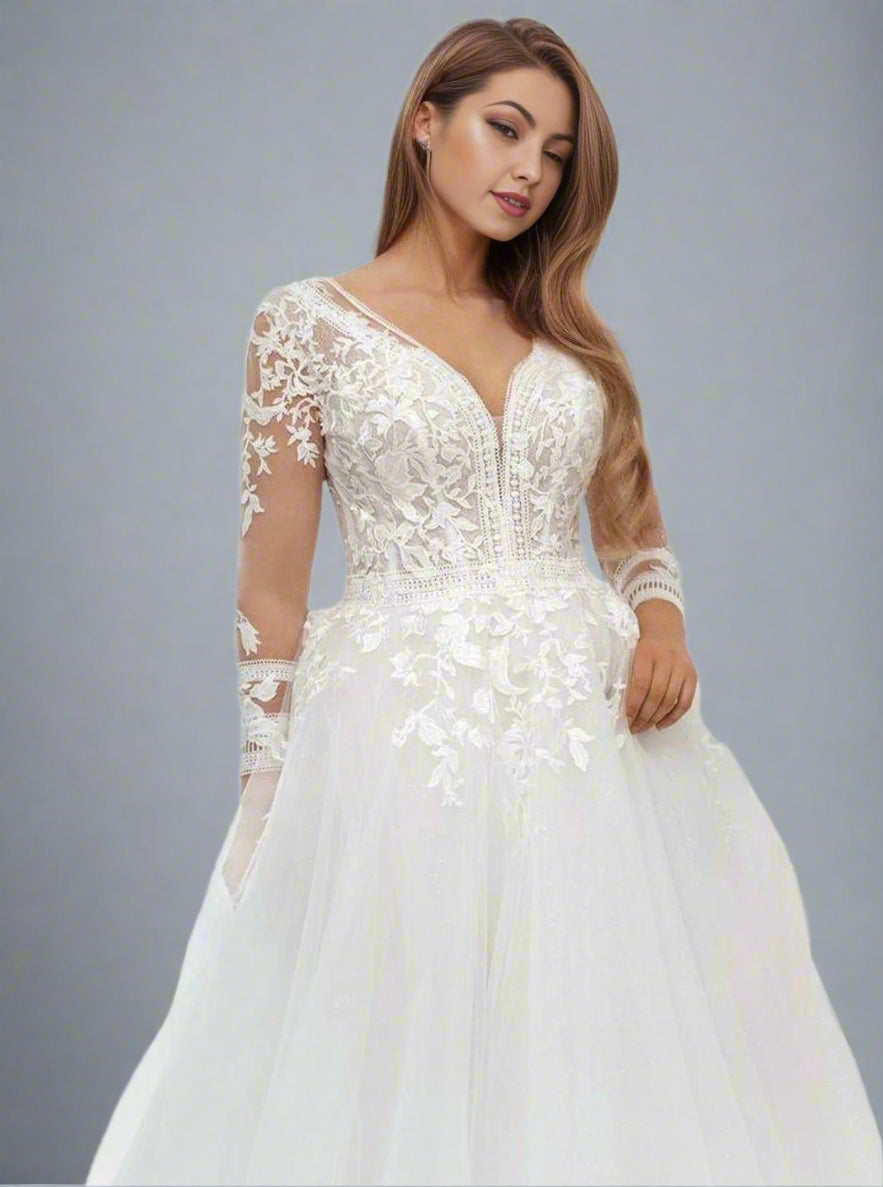 Detailed shot of the lace appliques on the wediing gown bodice and sleeves on plus size bride.