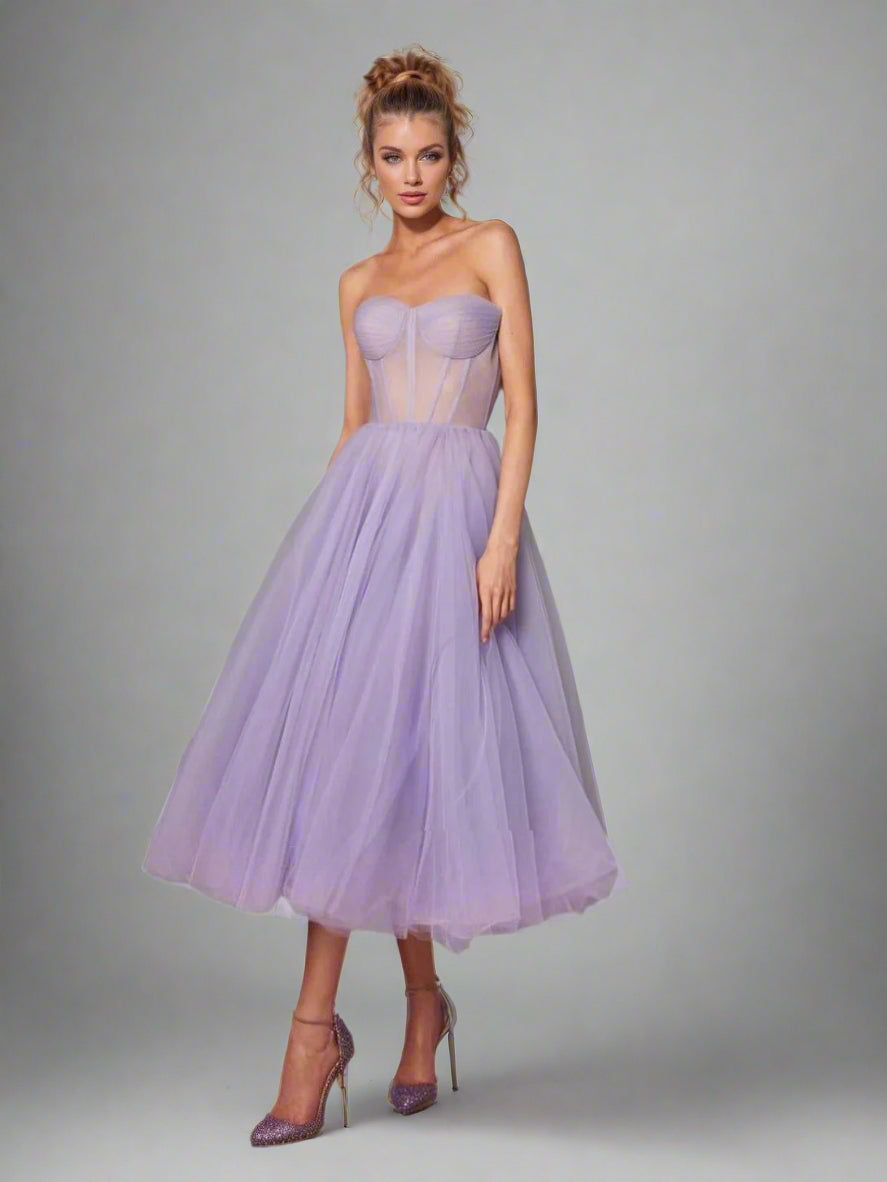 Woman in lavender color graceful tea-length formal dress with a fitted corset top.