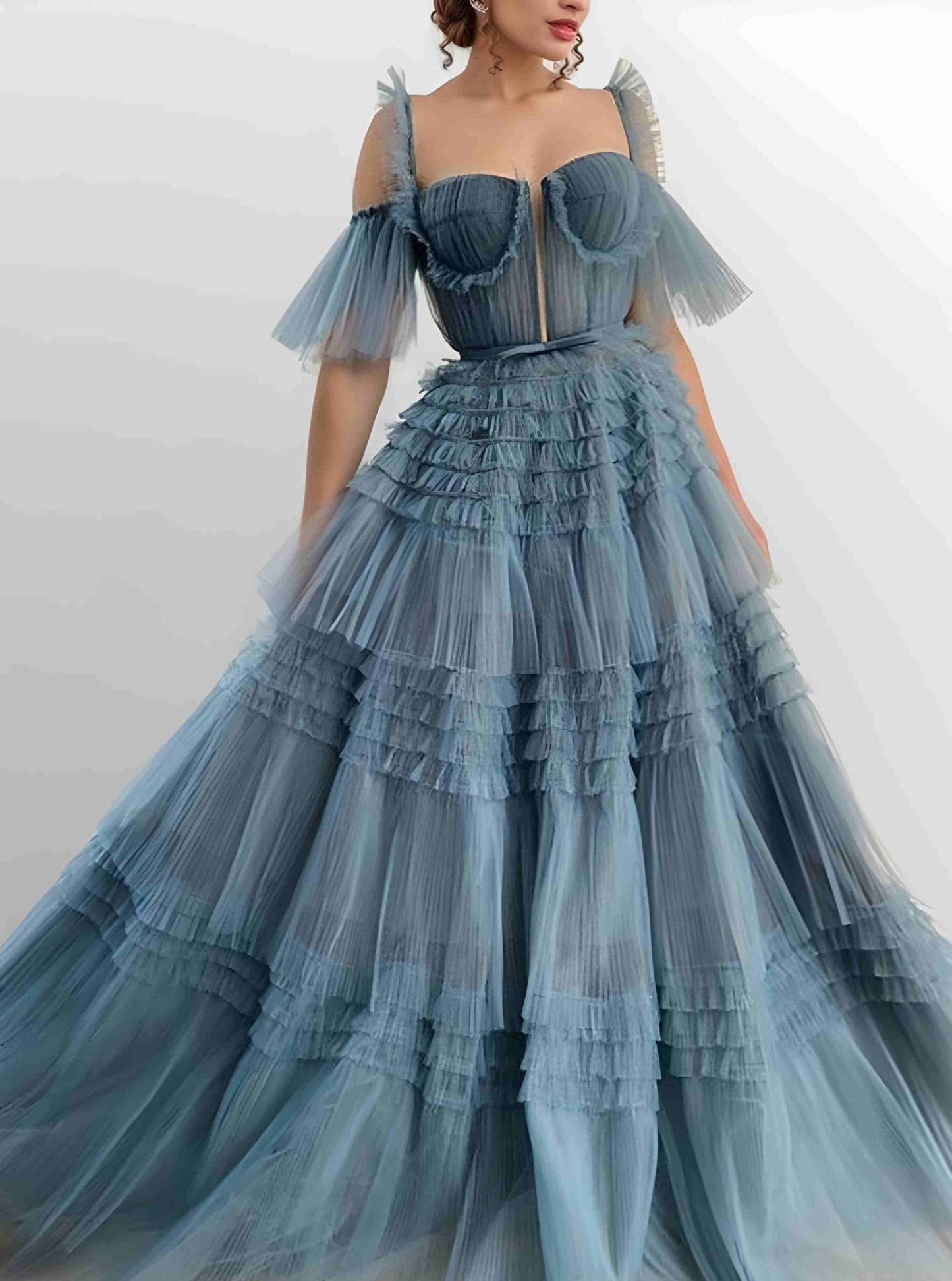 Model twirling in a tulle evening prom dress with tiered ruffles
