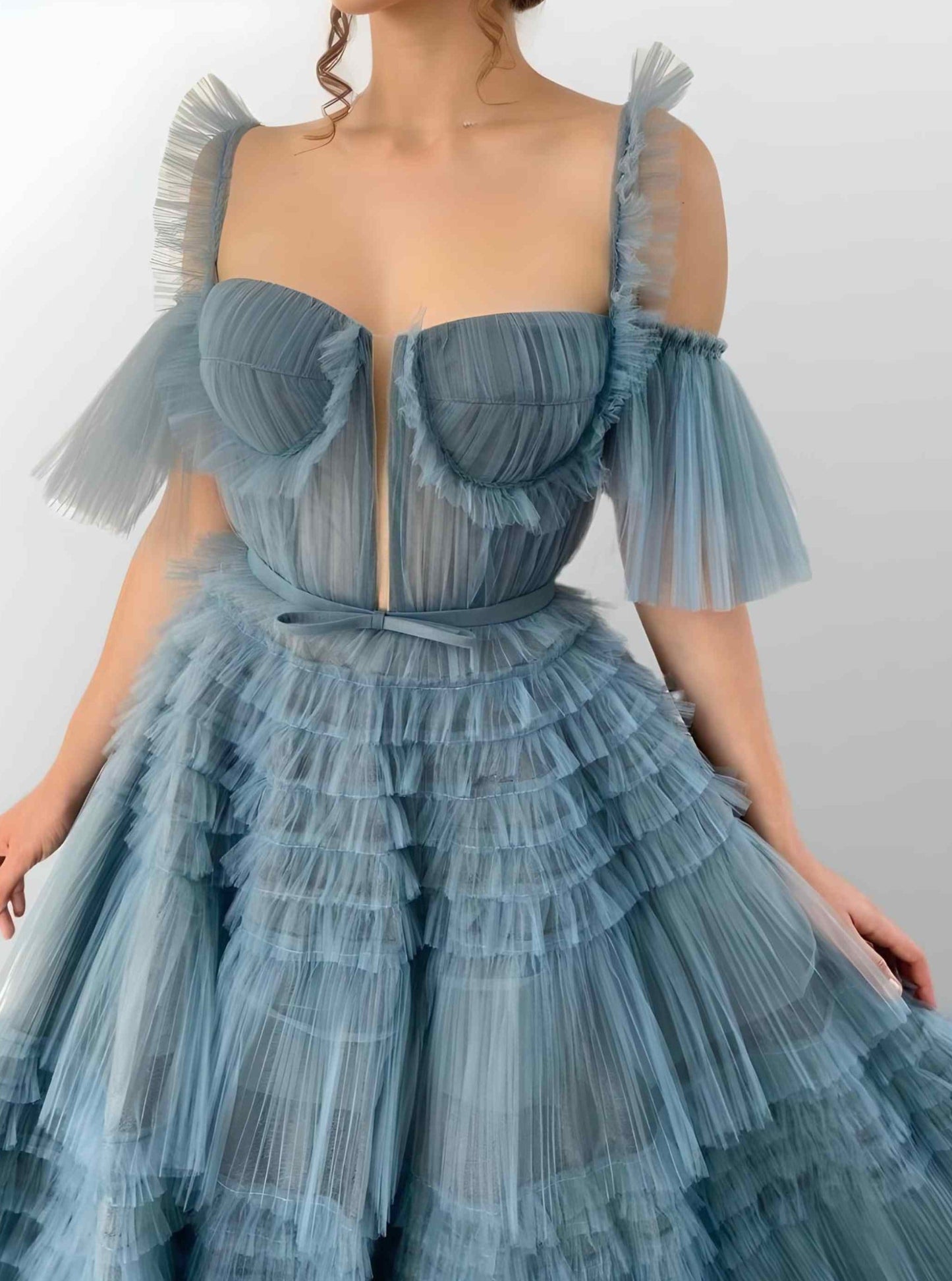 Close-up of fitted dusty blue bodice with delicate pleated details.
