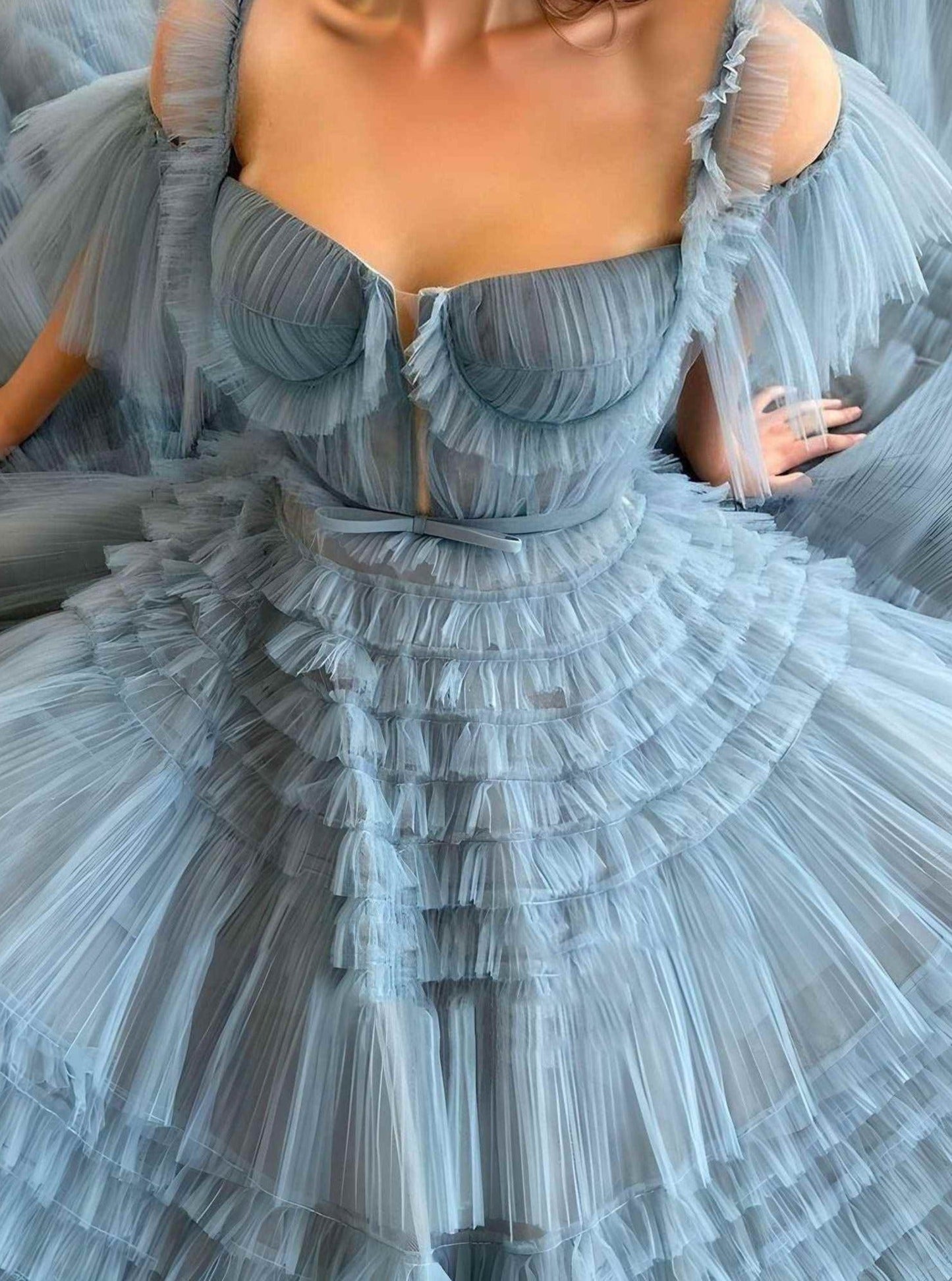 Woman posing in a glamorous ruffled A-line prom dress