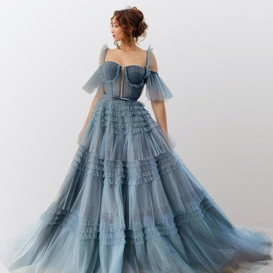 Woman wearing Willow Formal Dress in dusty blue showing tiered ruffled gown with sweetheart neckline.