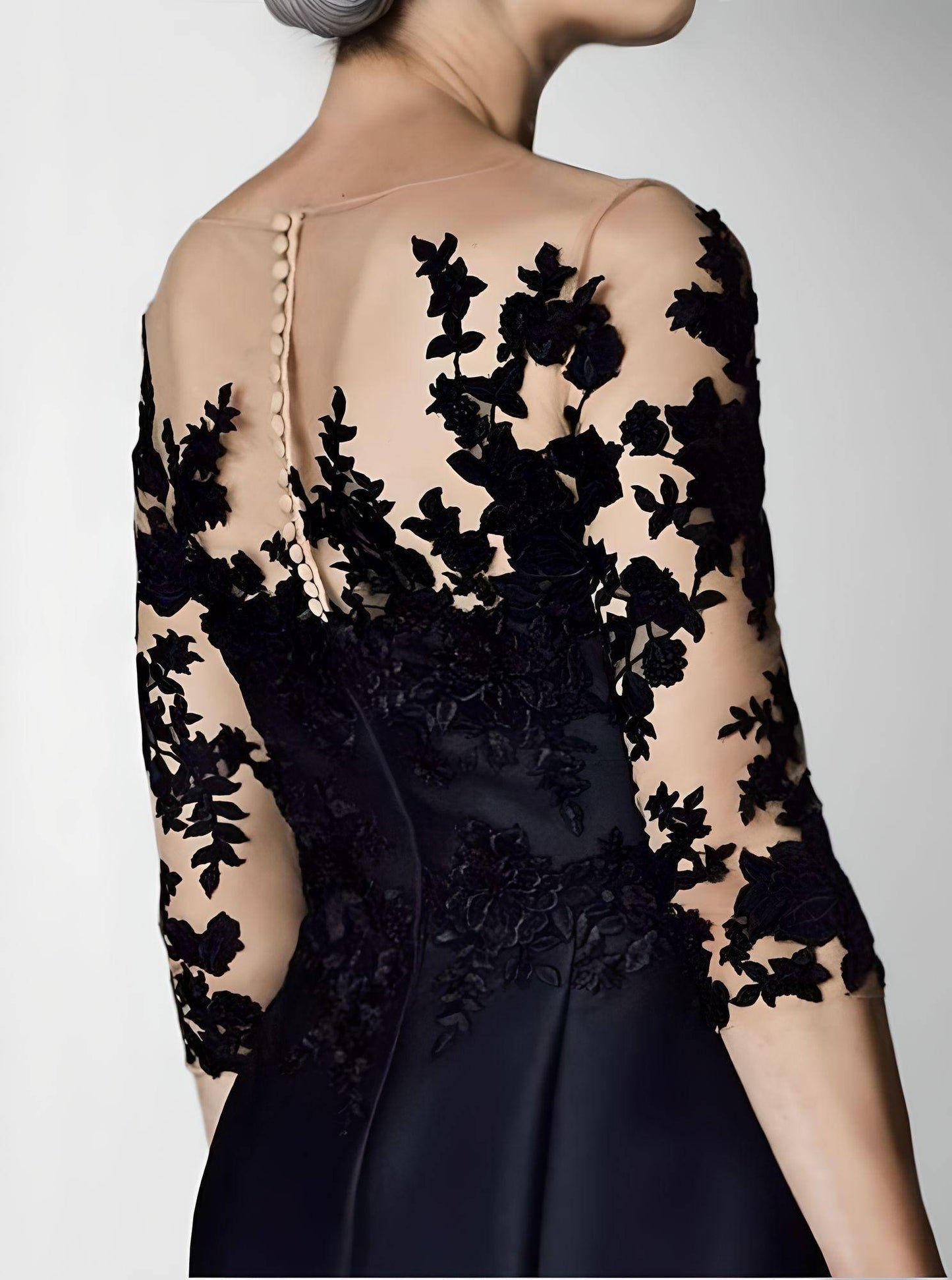 Close up of satin black dress with lace appliques for formal occasions and weddings.