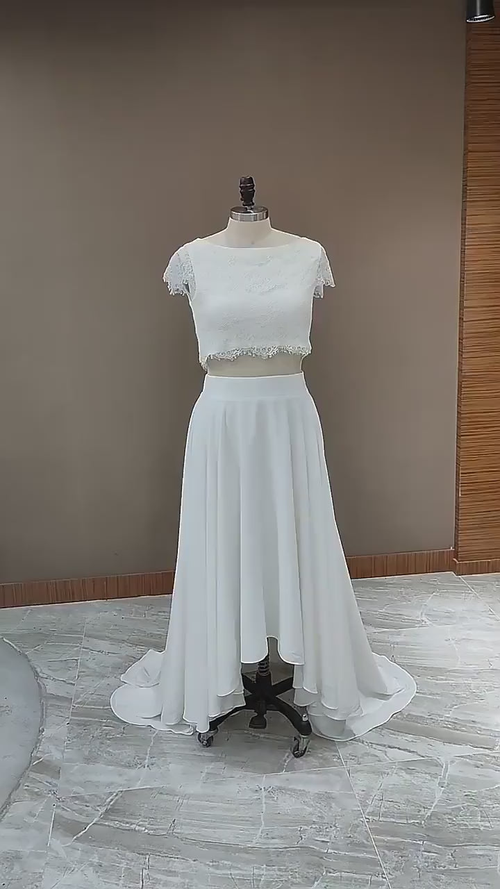 Showcase of bridal dress on a manequin. Wedding Dress with  fully laced top and a high-low skirt design.
