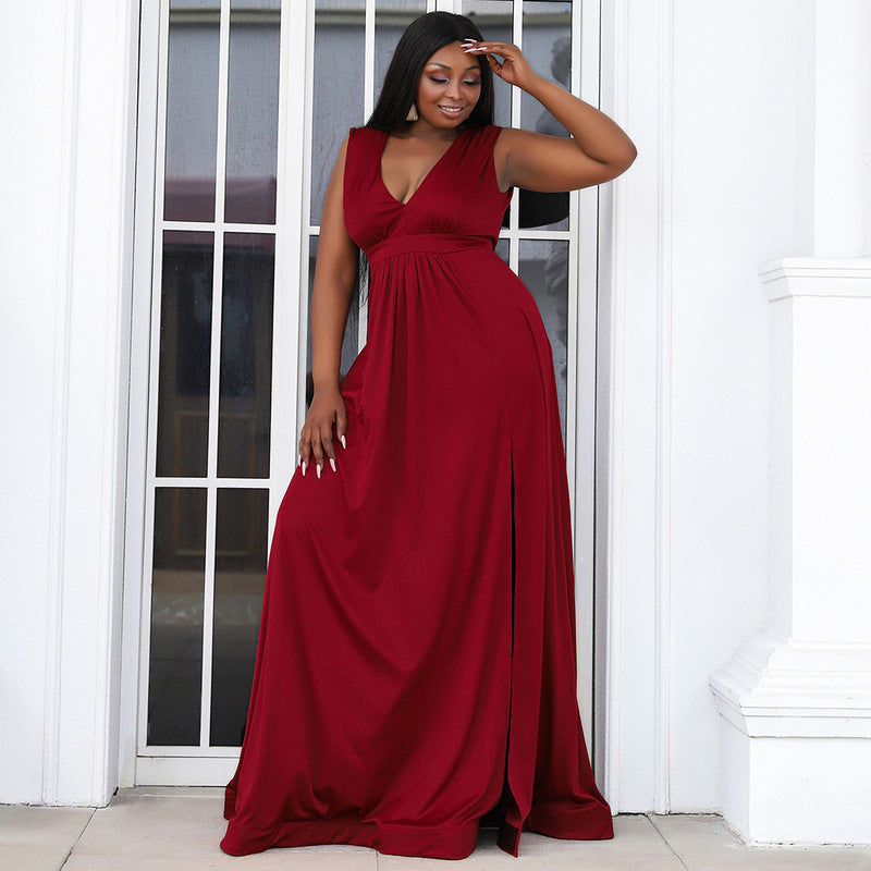 Curvy woman wearing a sleeveless gown with a V-neckline, high slit, and flowing A-line skirt, perfect for a chic and sophisticated look.