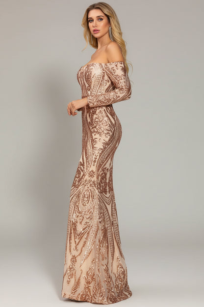Woman wearing a long, patterned off-shoulder dress on a plain background