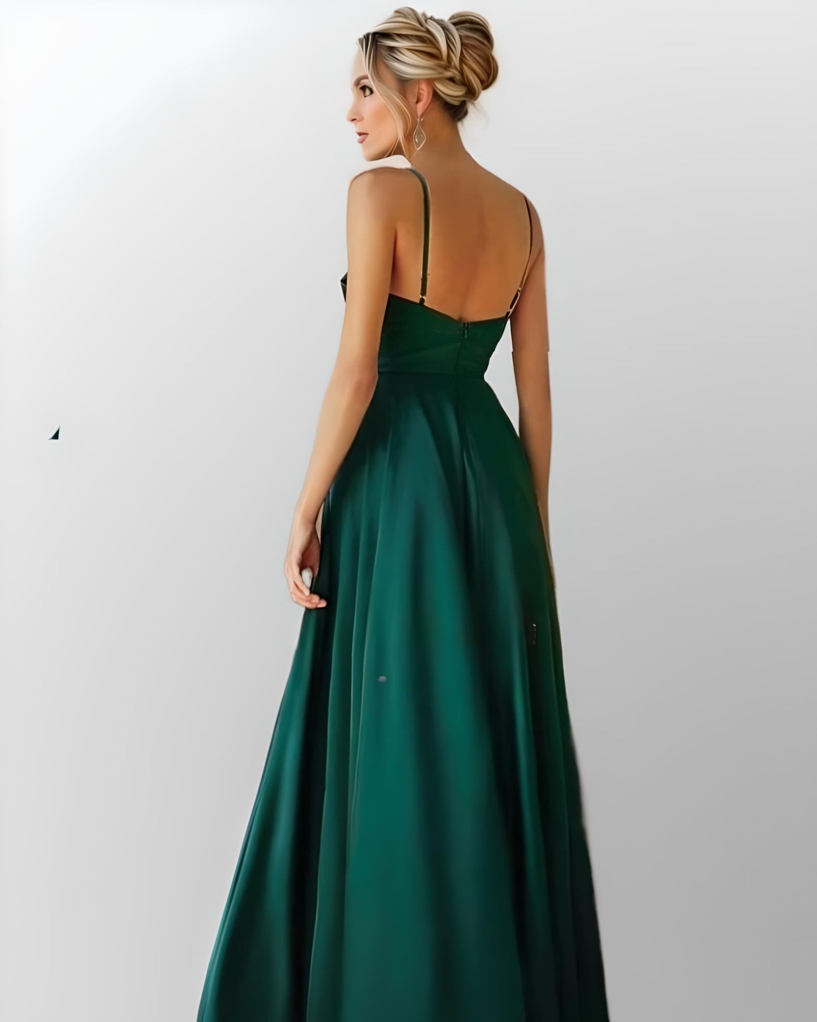 Blond woman in backless emerald green prom gown.