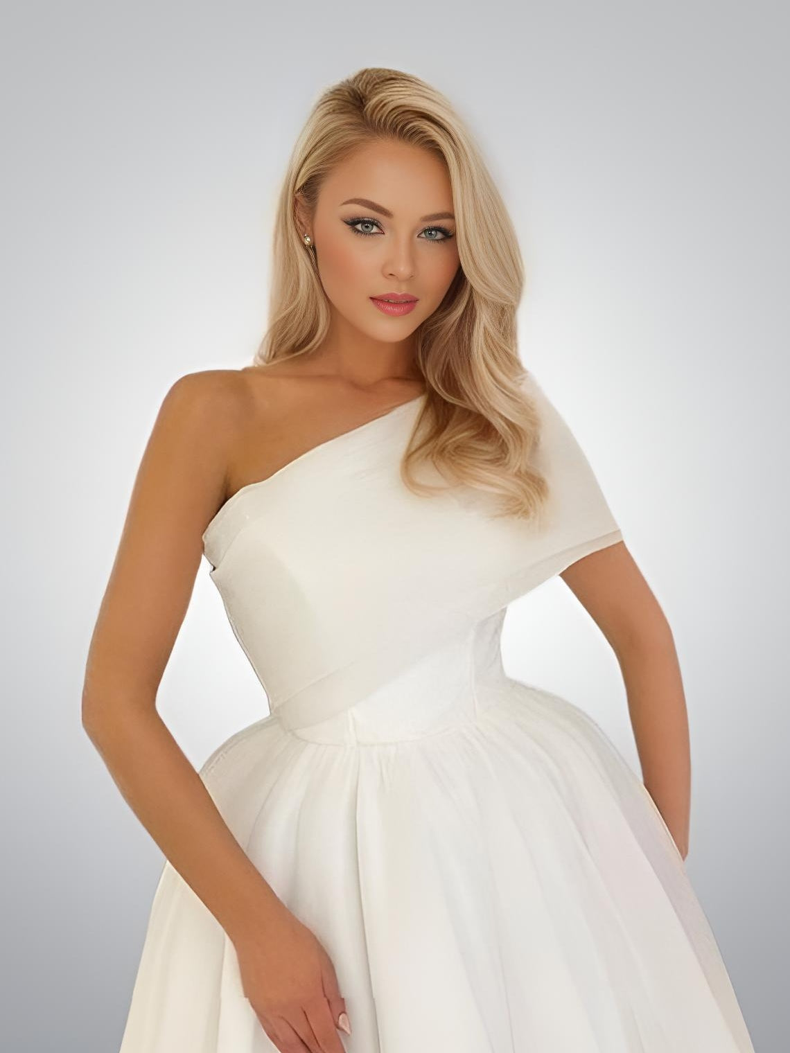 Fashionable woman posing in white simple one shoulder evening gown