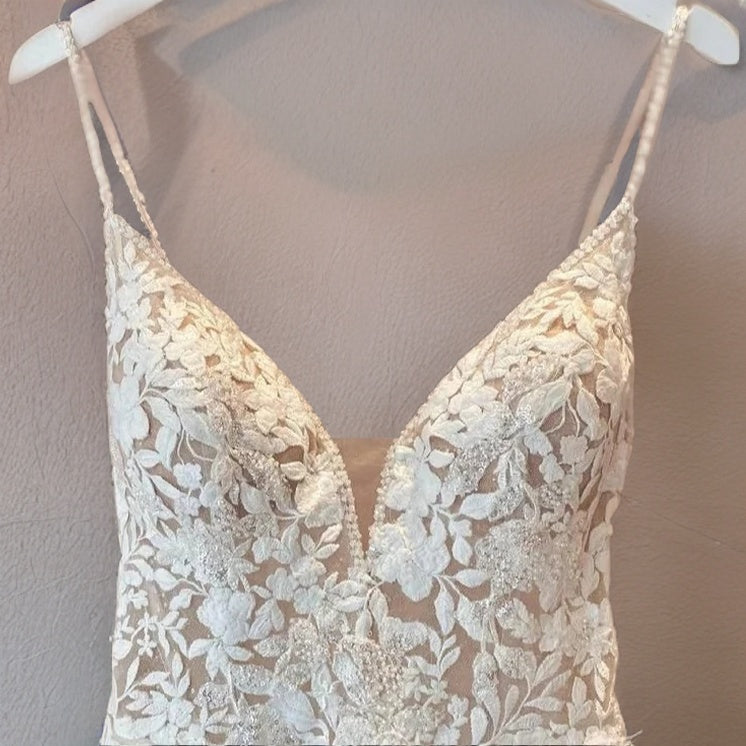 Bridal gown with delicate lace detailing on hanger