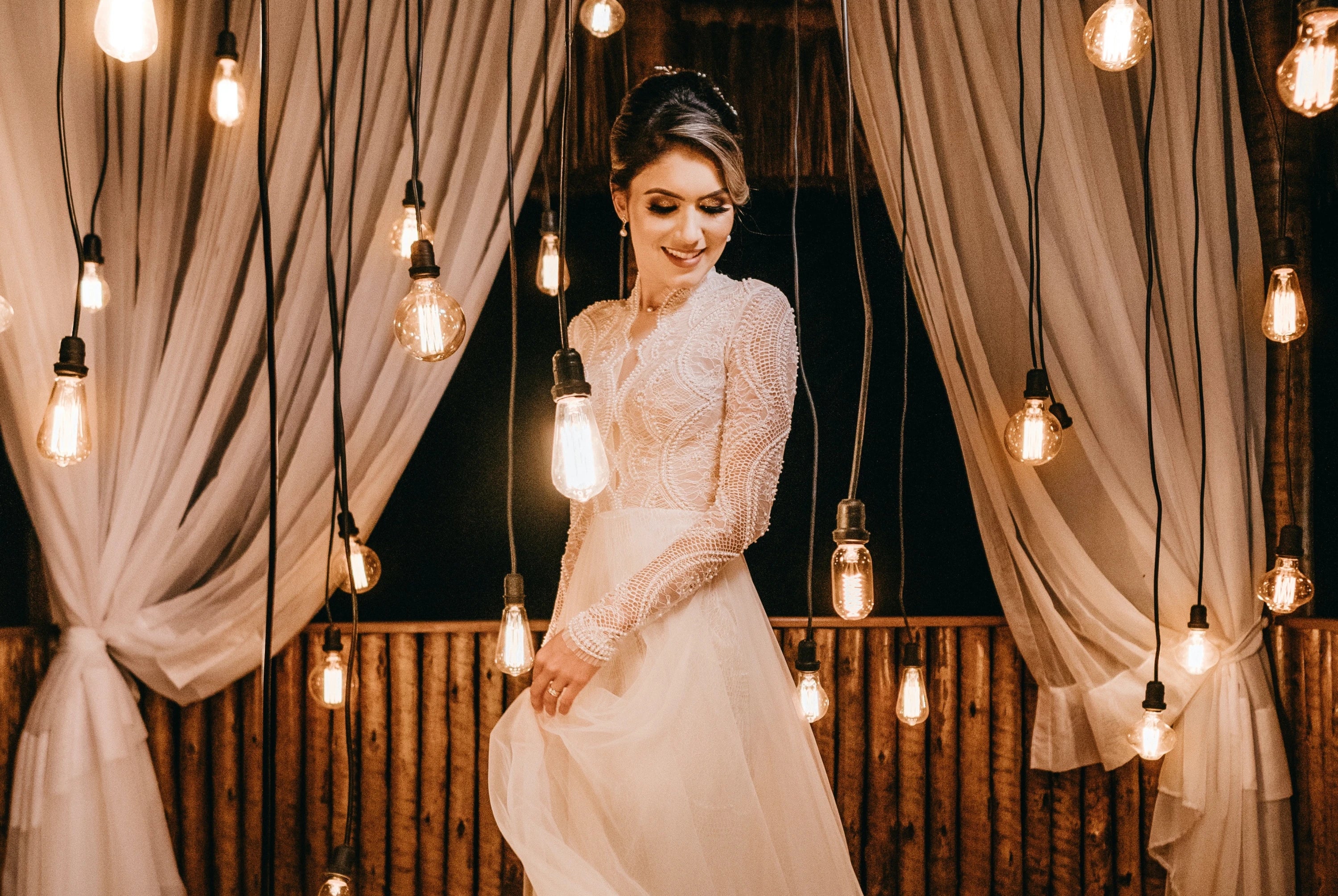 Smiling bride in Lace Wedding Gown in Bulb Lights