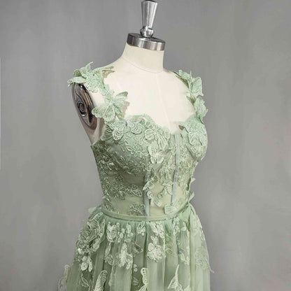 Model of a sage green color prom dress with 3D butterfly lace appliques.